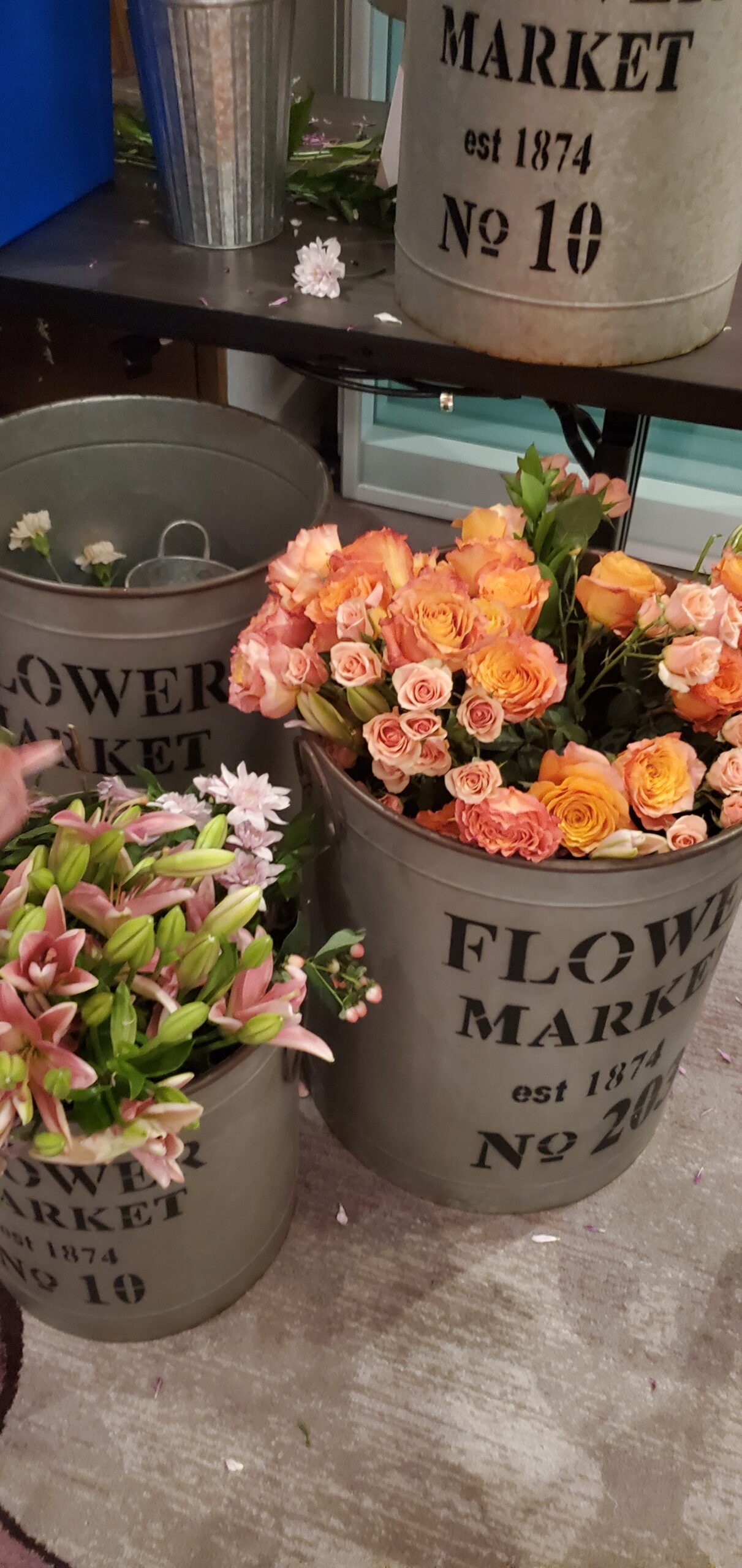 Galvanized flower buckets with fresh garden roses and lilies at the custom bouquet bar