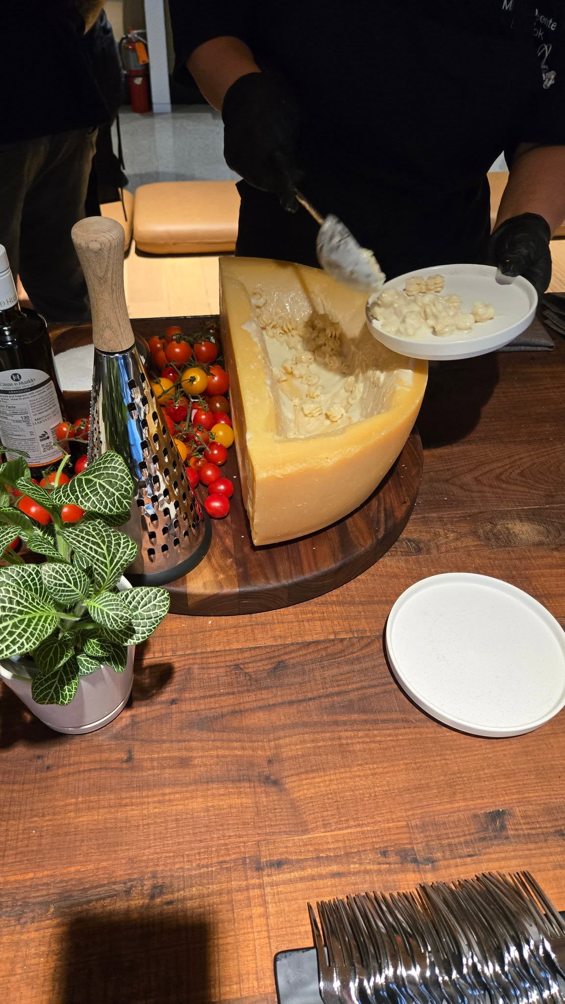 Executive Chef tossing pasta inside a whole wheel of Parmigiano Reggiano