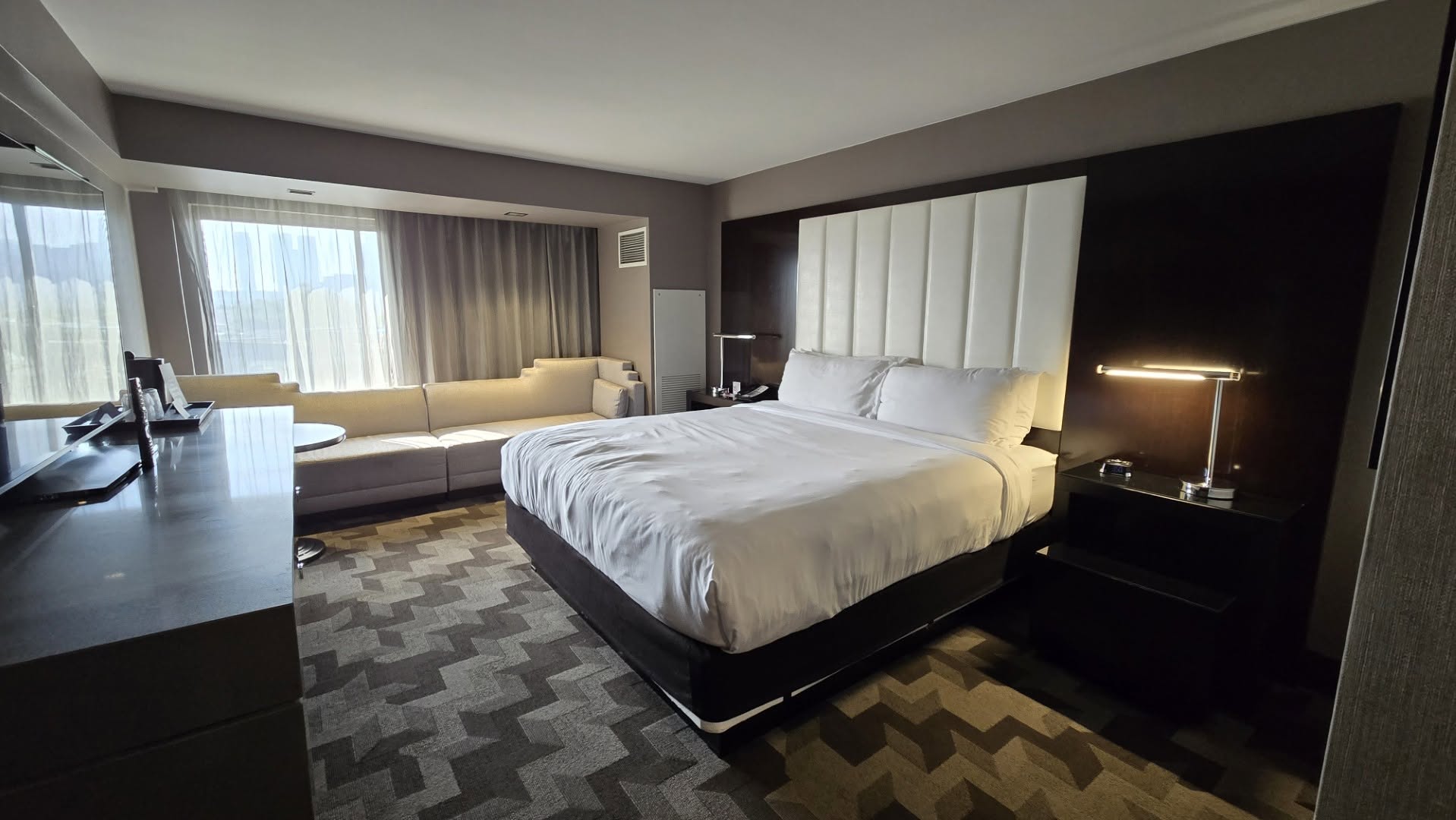 12th floor King Suite bedroom overview with tall white leather headboard
