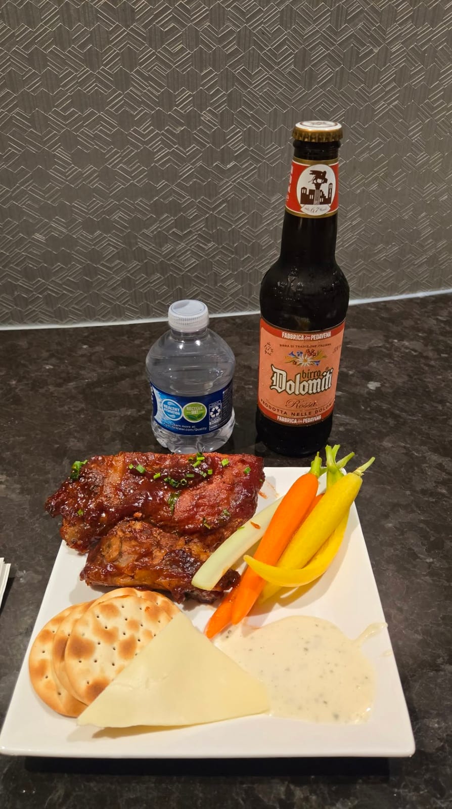 M Club evening plate: Barbecue ribs, gourmet cheeses, crackers, fresh carrots, and Italian beer