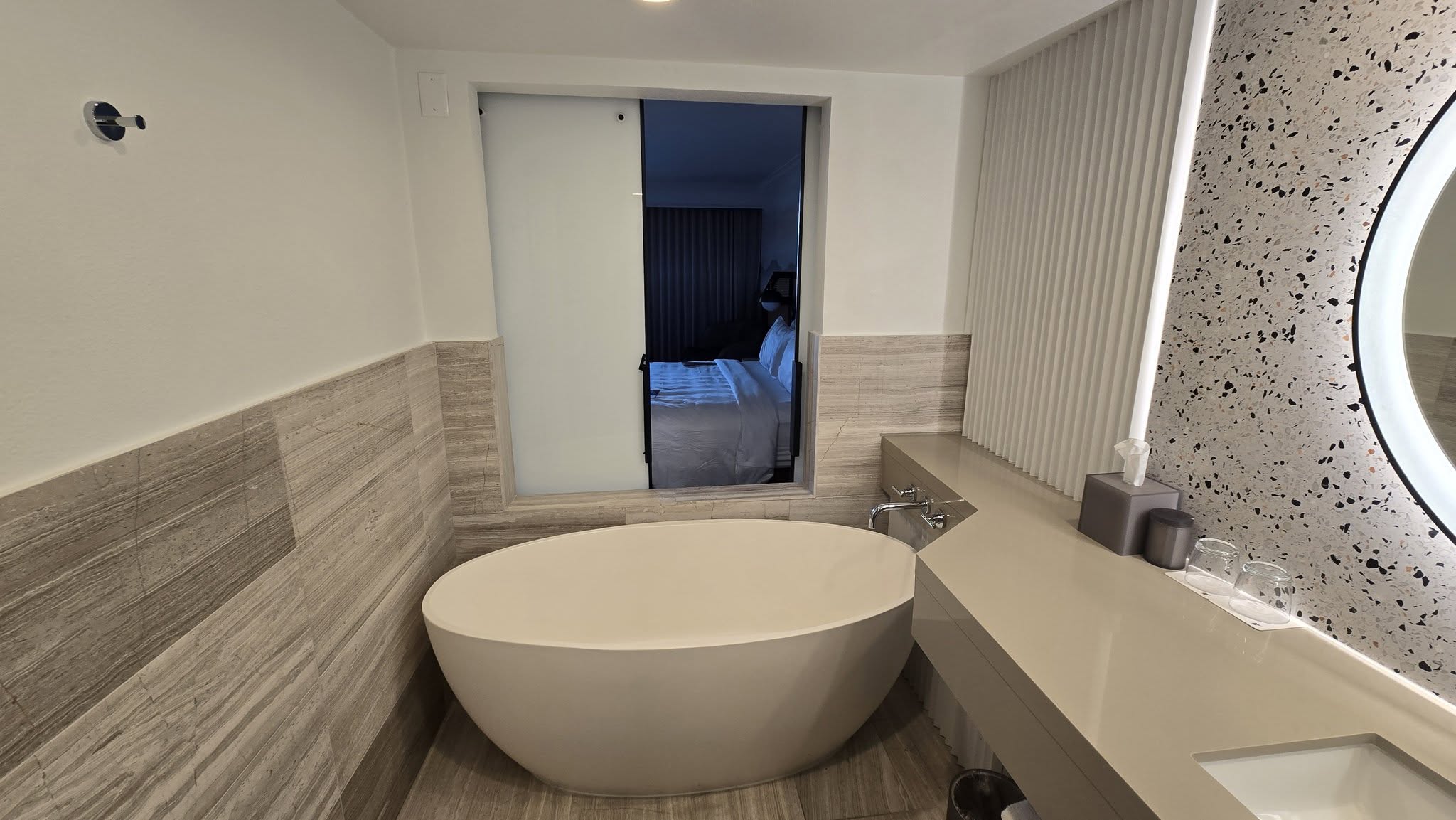 Freestanding oval soaking tub filling with warm bathwater
