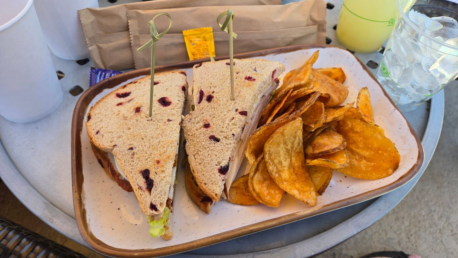 Poolside artisan turkey club sandwich on cranberry bread with kettle chips