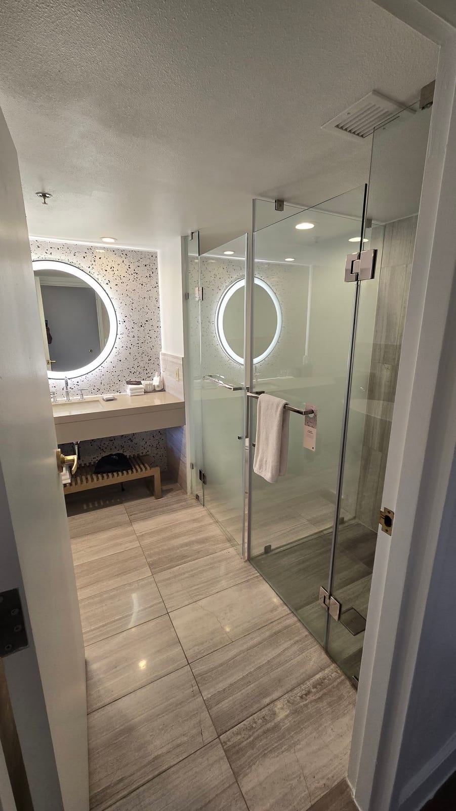 Renovated master bathroom with glass shower enclosure and quartz vanity