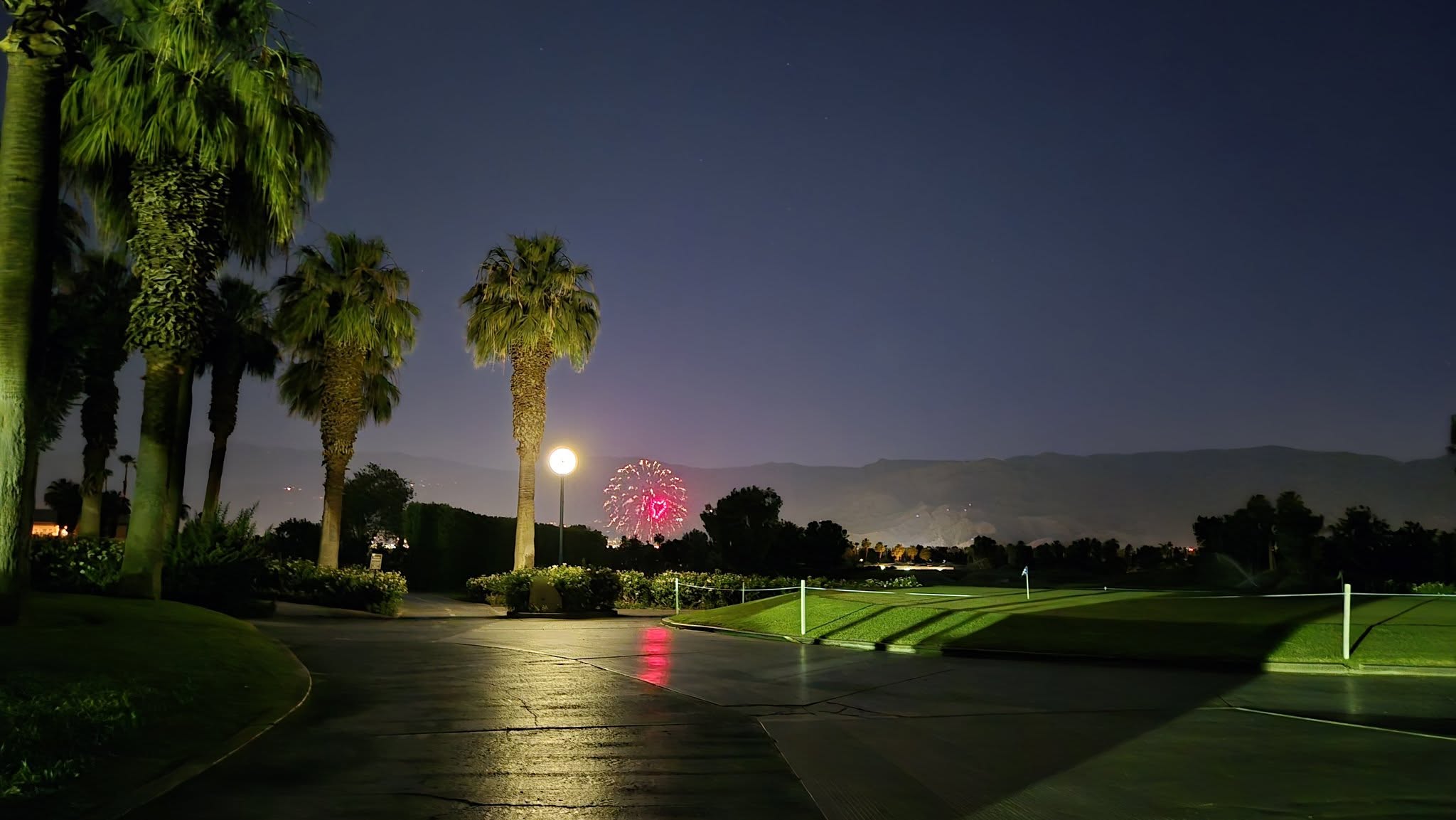 Fireworks display exploding over the resort lake and desert mountains