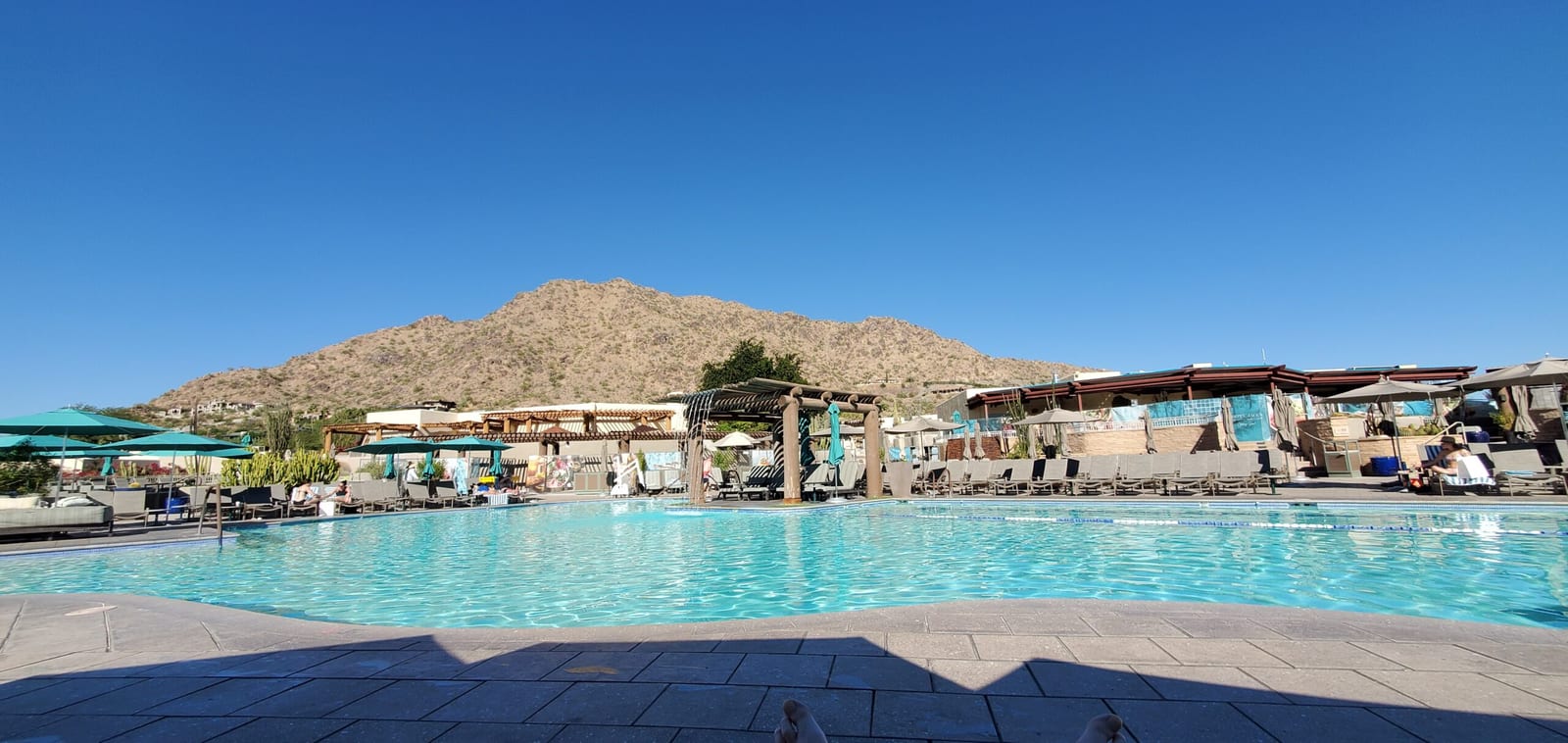 Daytime panorama of the Jackrabbit Pool under clear blue Arizona skies