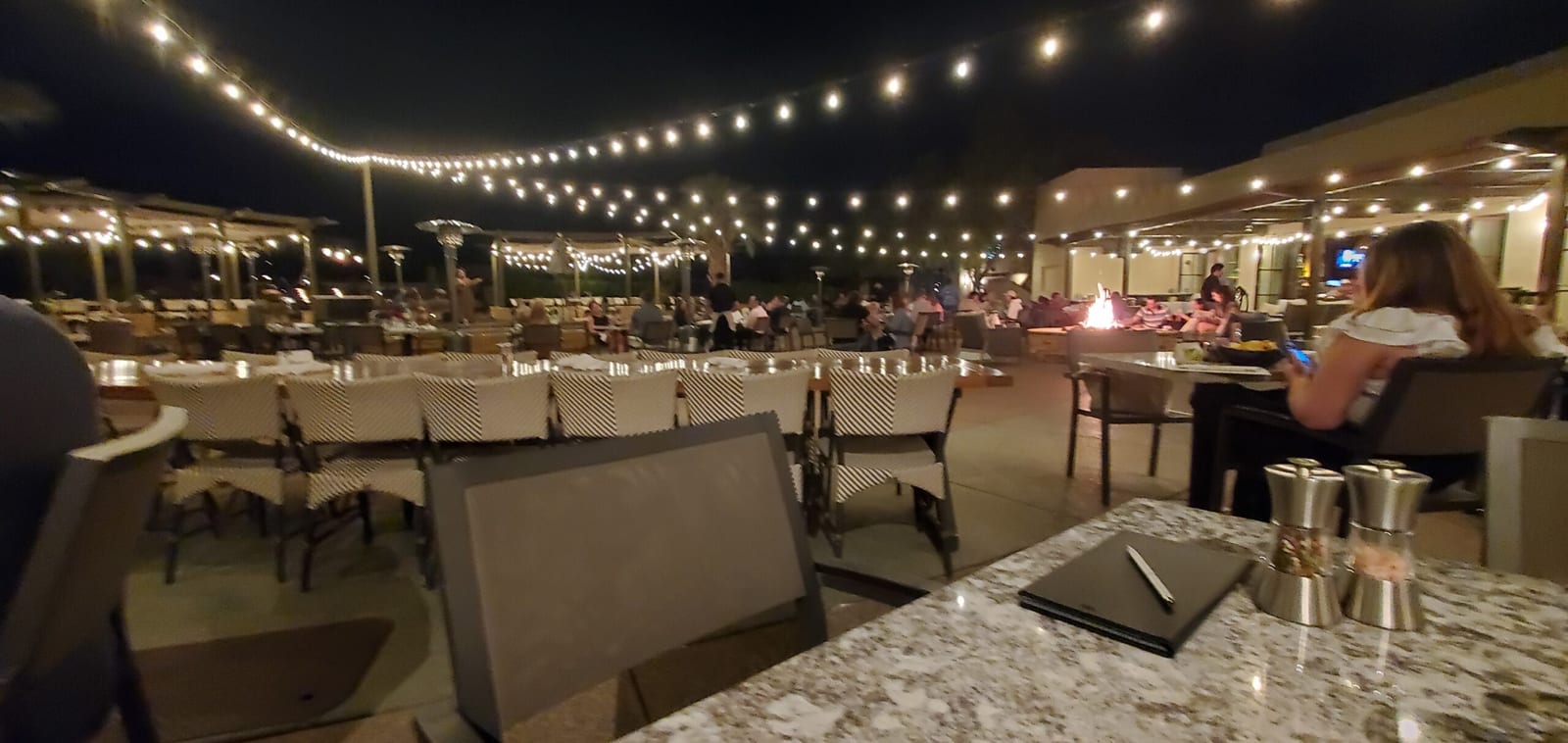 Rita's Cantina terrace dining under string lights with crackling fire pit