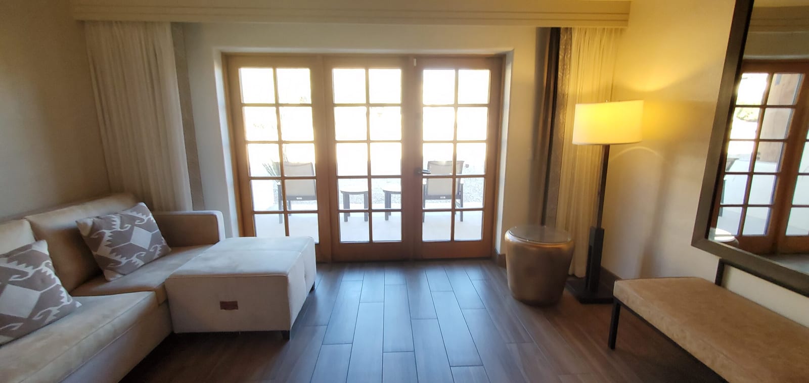 Sectional chaise lounge situated beside French terrace doors