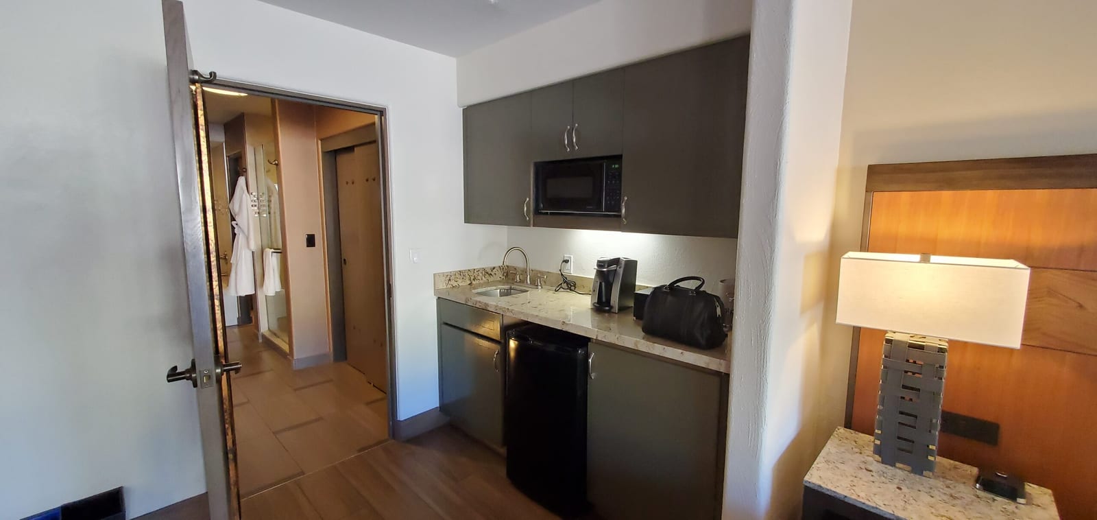 Kitchenette wet bar counter with microwave, sink, and mini fridge
