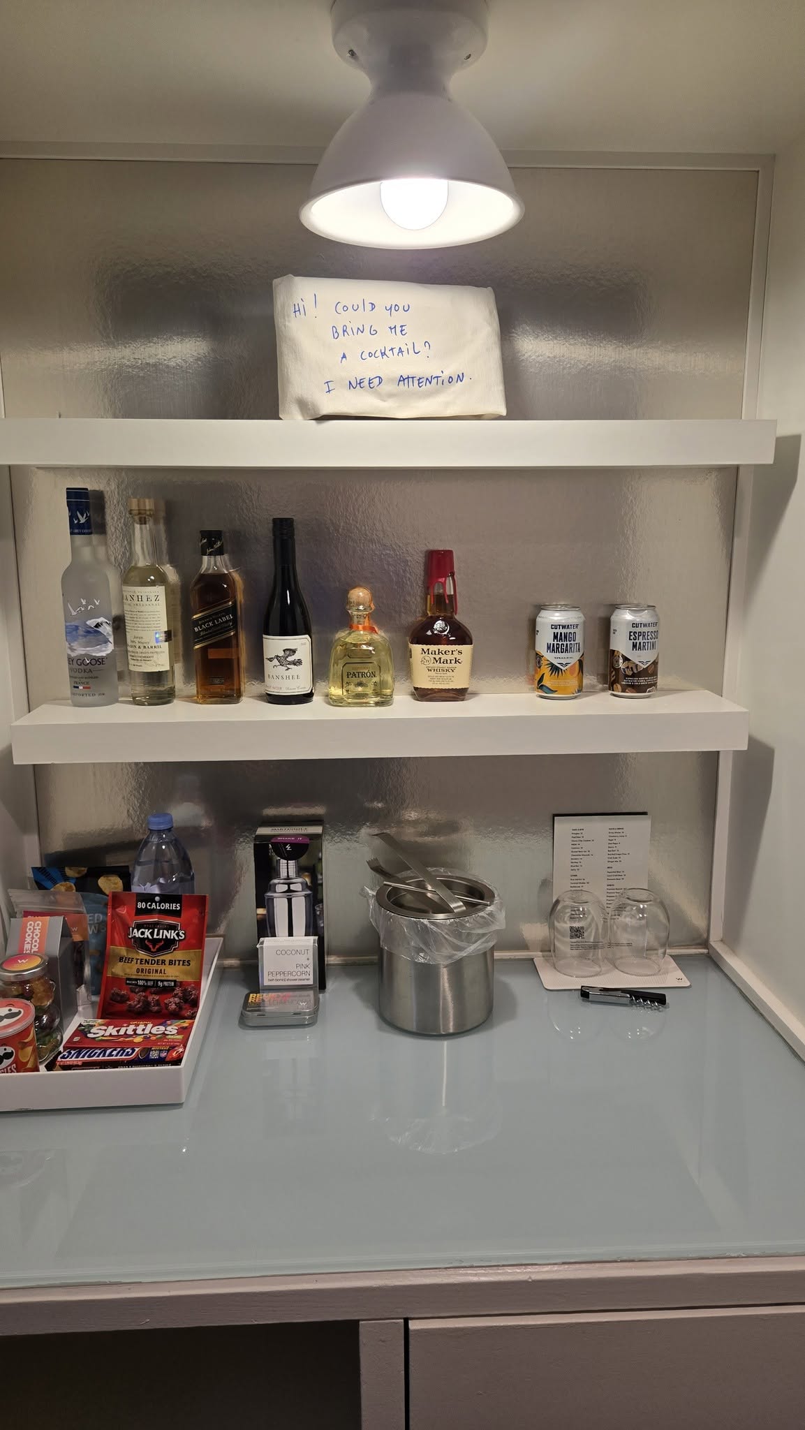 Playful W cocktail pillow sign on the bar shelf
