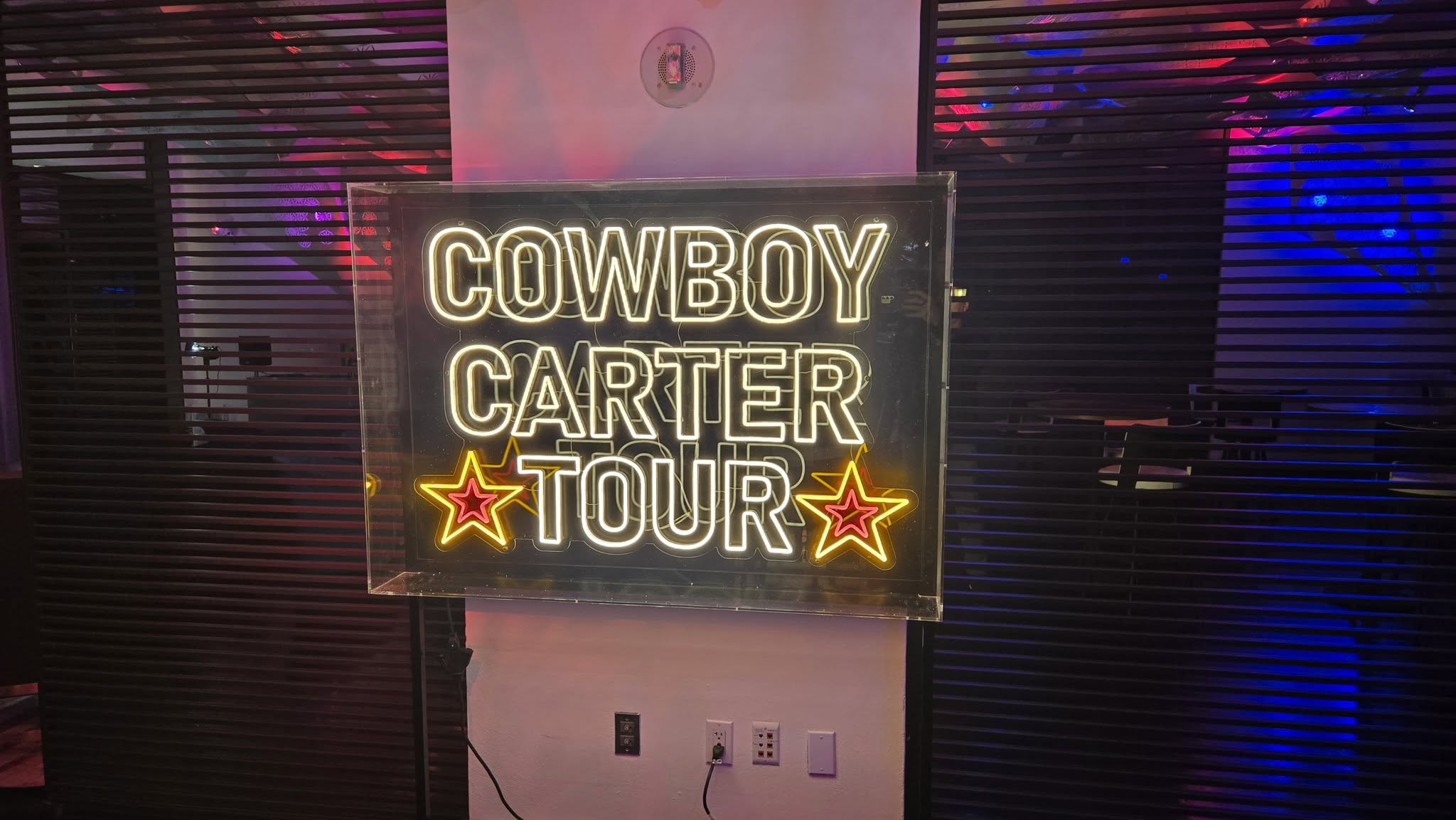 Illuminated Cowboy Carter neon sign and cowboy boots display