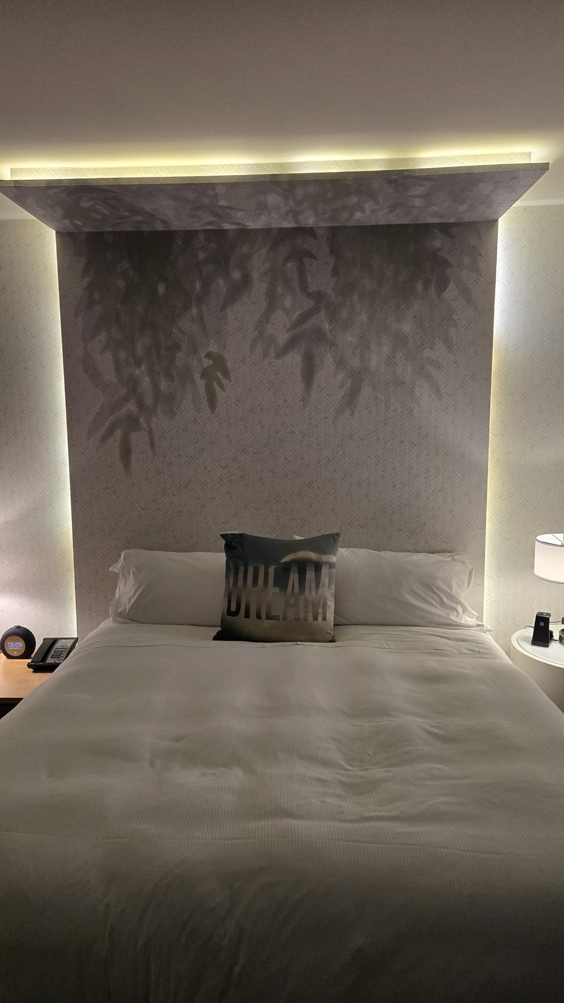 Vertical composition of master King bed and bedside lighting sconce