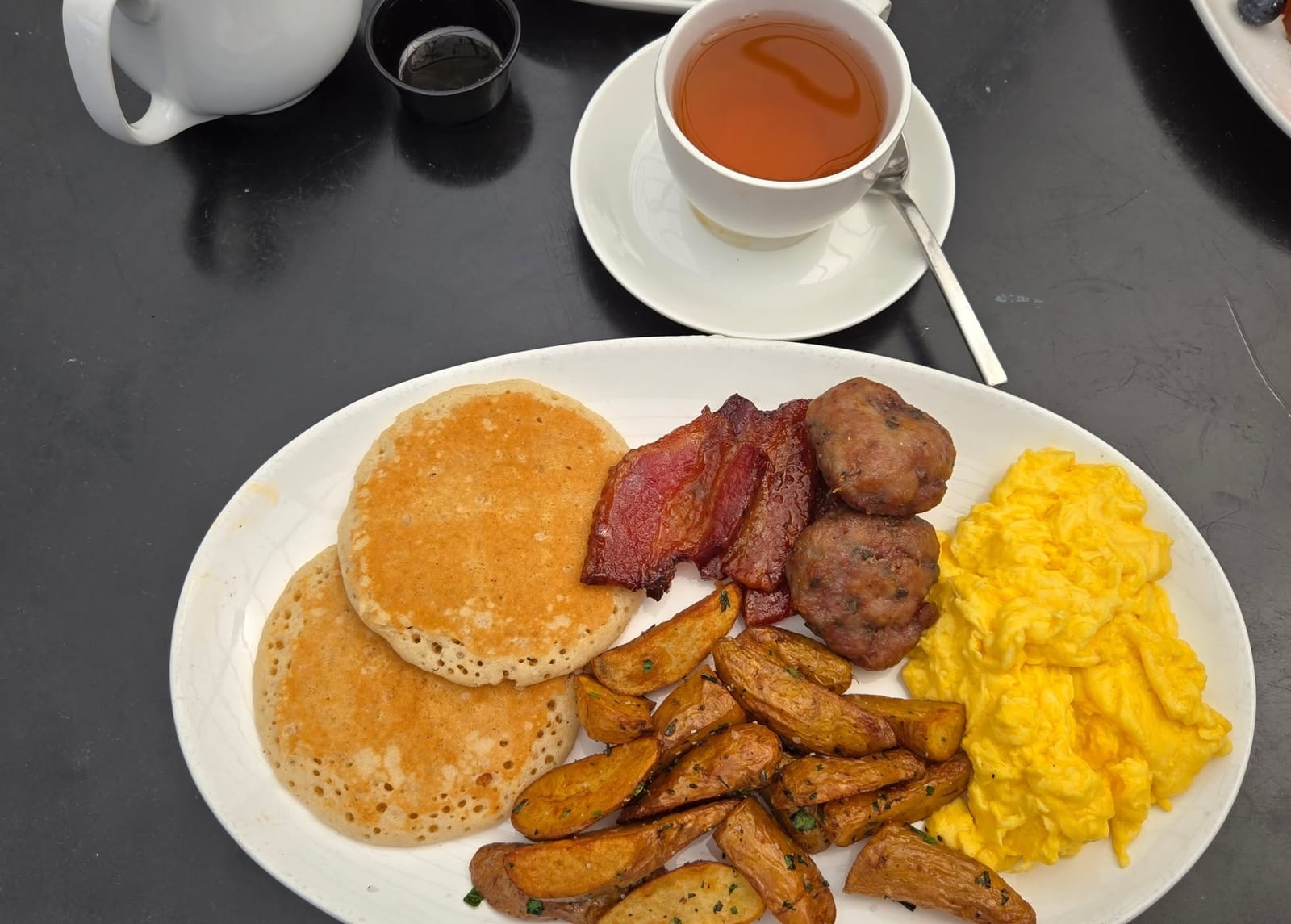 The American breakfast platter with scrambled eggs, bacon, roasted potatoes, and toast